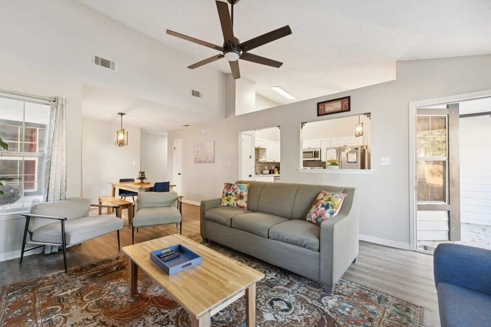 An inviting living space with a gray sofa and a view into the kitchen.
