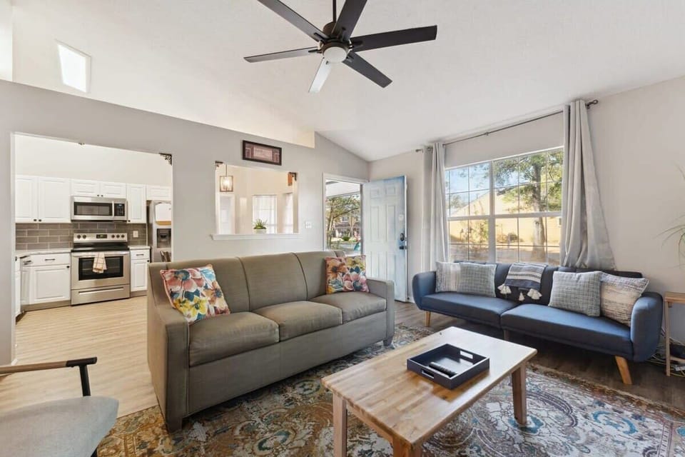 The living room features comfortable seating, vaulted ceilings, and plenty of natural light.