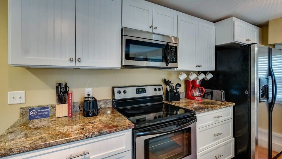 Bright kitchen with white cabinets and granite countertops.