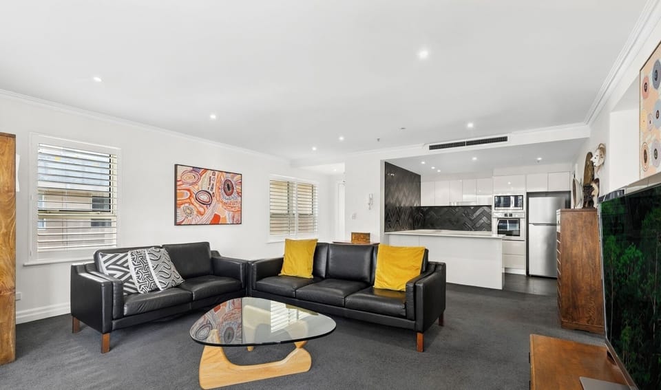 modern living space with a dark sofa accented by vibrant yellow cushions.