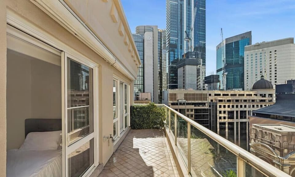 An airy balcony overlooking a dense city skyline.