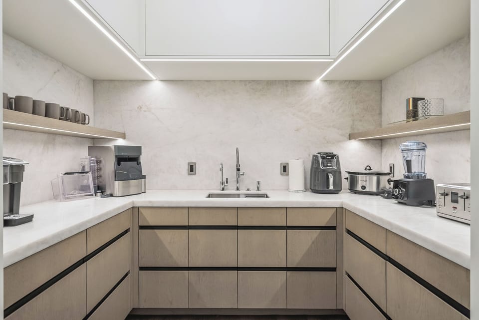 gorgeous kitchen area with sleek appliances and marble counters and backsplash