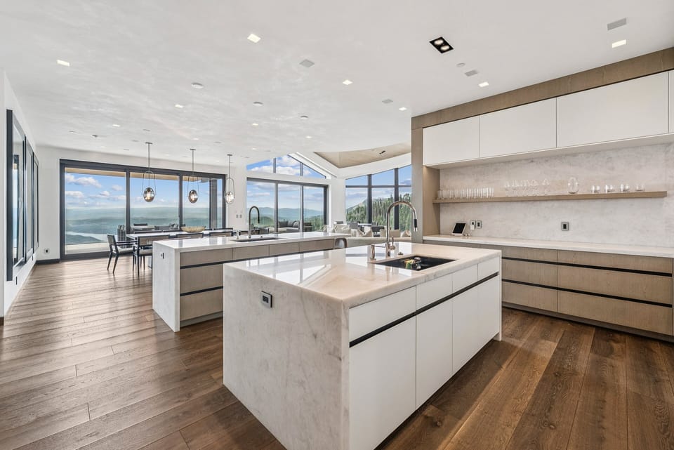 modern kitchen with marble islands - one is eat-in with seating and the other has a sink in it