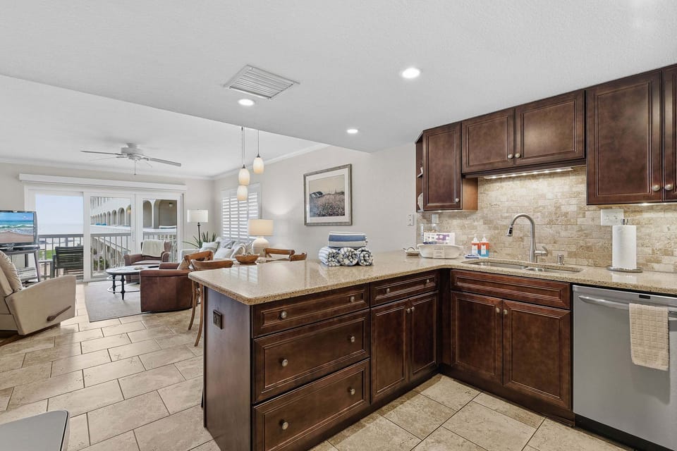 Prepare meals with ease in this updated kitchen featuring granite countertops, modern appliances, and an open layout flowing into the living area. A perfect beach stay for relaxing coastal vacations.