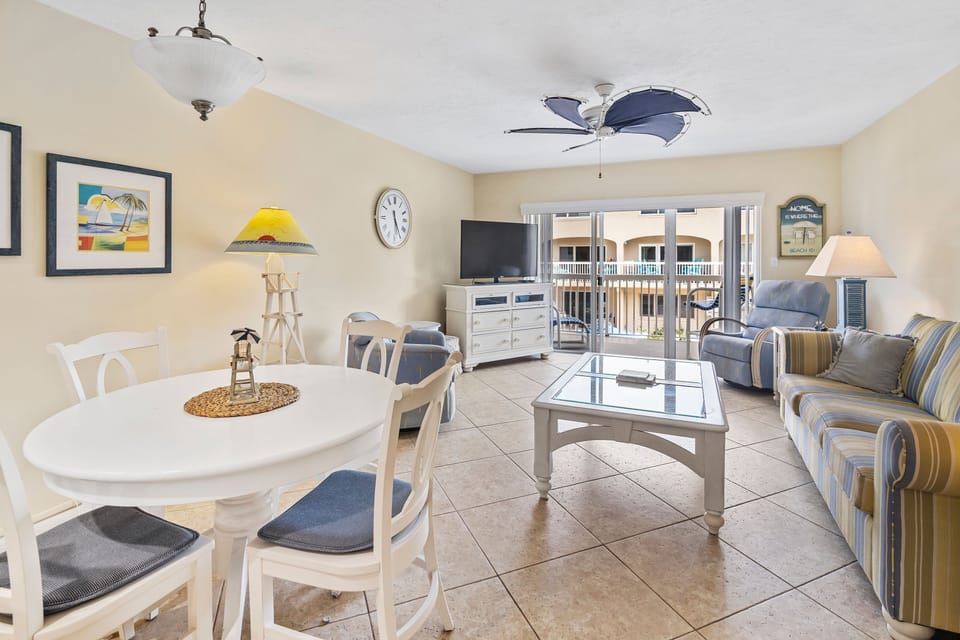 Relax in this sunny beach-inspired living area featuring comfy seating, a flat-screen TV, and direct access to a private balcony—perfect for unwinding after a day by the ocean.