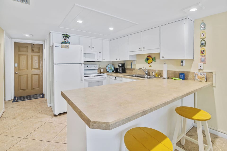 Whip up seaside favorites in this bright, fully equipped kitchen featuring modern appliances, ample counter space, and a breakfast bar—perfect for enjoying meals during your beach vacation.