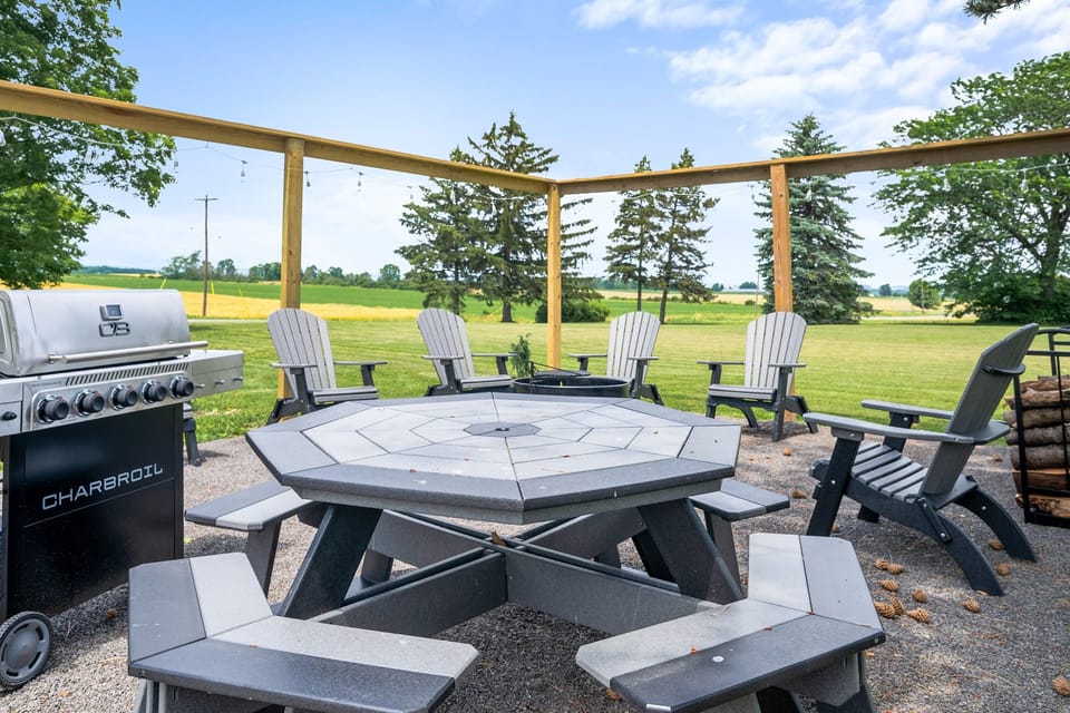 Another angle of the inviting fire pit area with charming farmhouse views and lush landscape