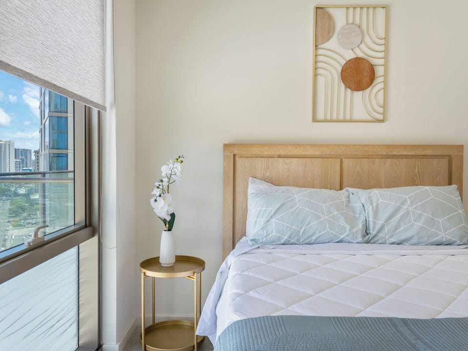 Bedroom - Enjoy the guest bedroom’s inviting design with a queen bed, closet, and abundant natural light from the floor to ceiling windows, providing comfort and convenience during your extended Honolulu stay.