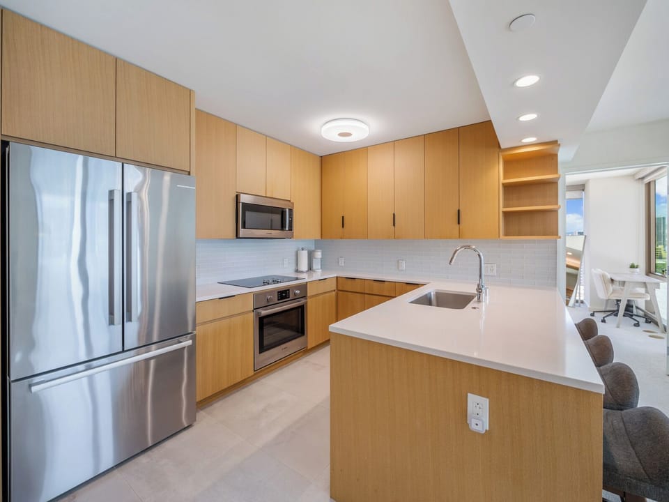 Kitchen - Cook and gather in the Sky Ala Moana kitchen, where stainless steel appliances, long counters, and stylish cabinetry blend function with Honolulu’s contemporary island living.