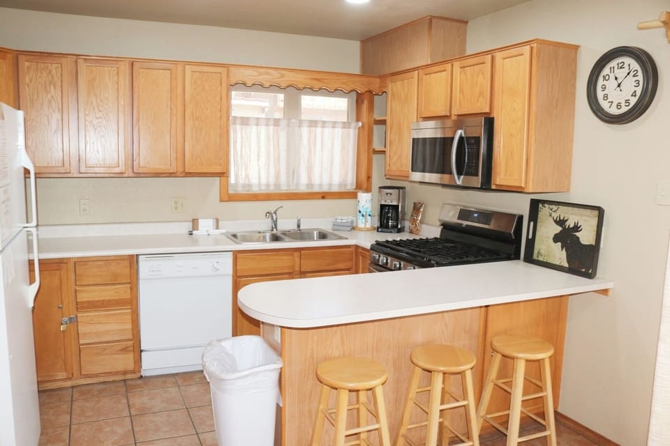 A fully equipped kitchen awaits you with warm oak cabinetry, modern appliances, and a handy breakfast bar where you can enjoy your morning coffee in comfort.