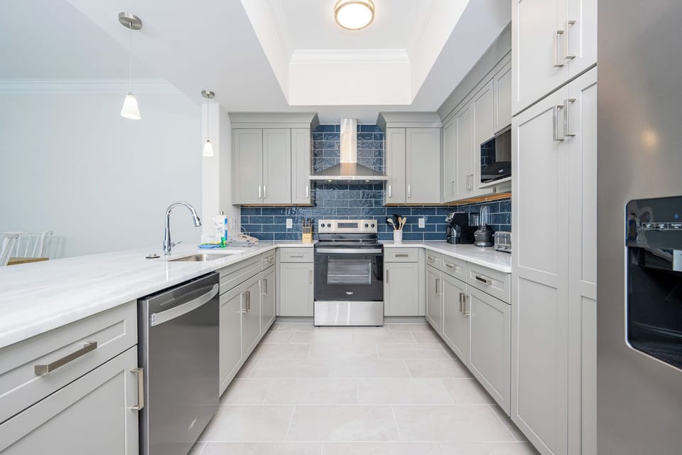 Prepare meals in this stylish kitchen featuring sleek cabinetry, modern appliances, and elegant design