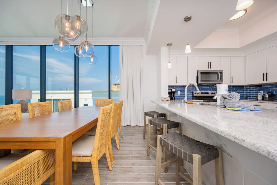 Gather around the spacious dining table, complemented by stylish seating and large windows inviting beachfront views