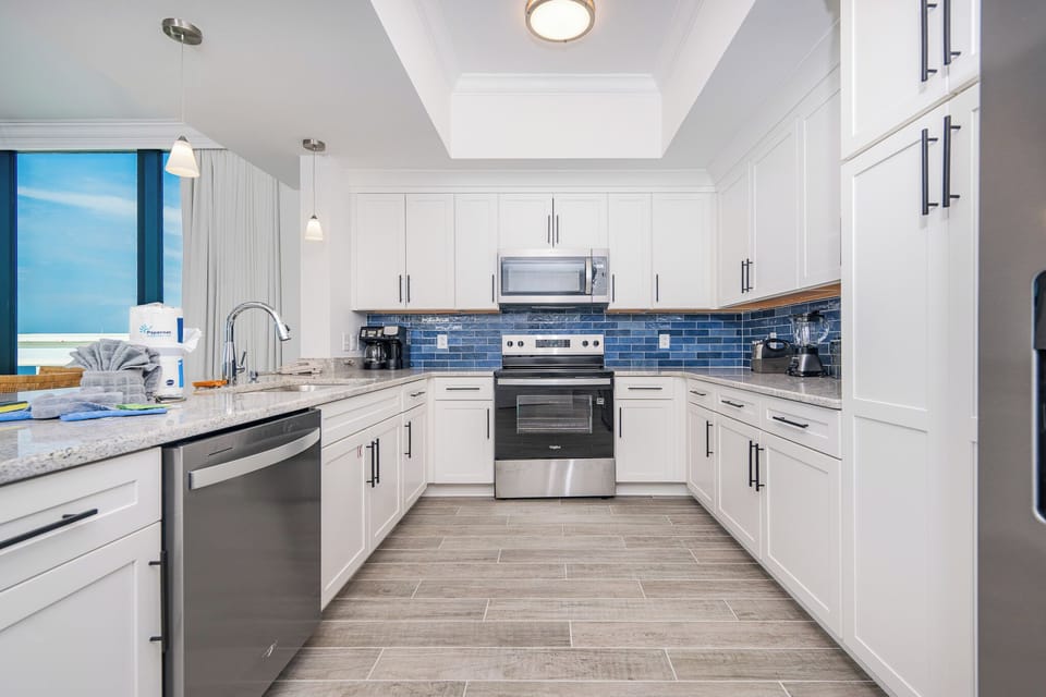Prepare meals in this sleek kitchen featuring sleek cabinetry, stainless appliances, and a stylish backsplash