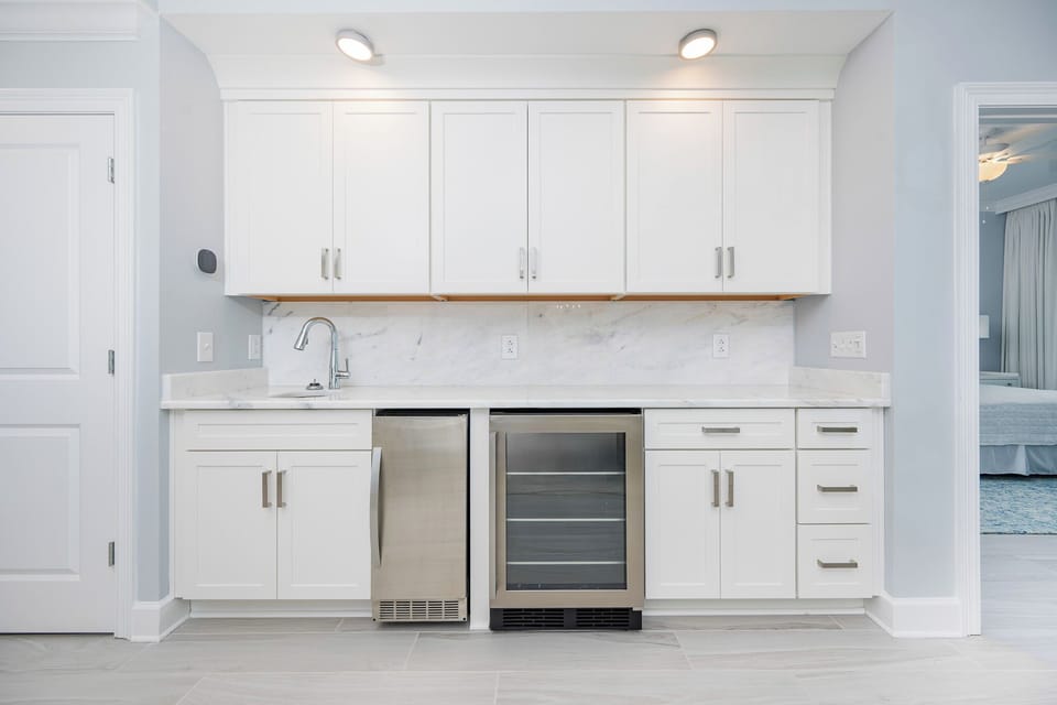 Prepare snacks and drinks in this sleek wet bar featuring a wine cooler and stylish design