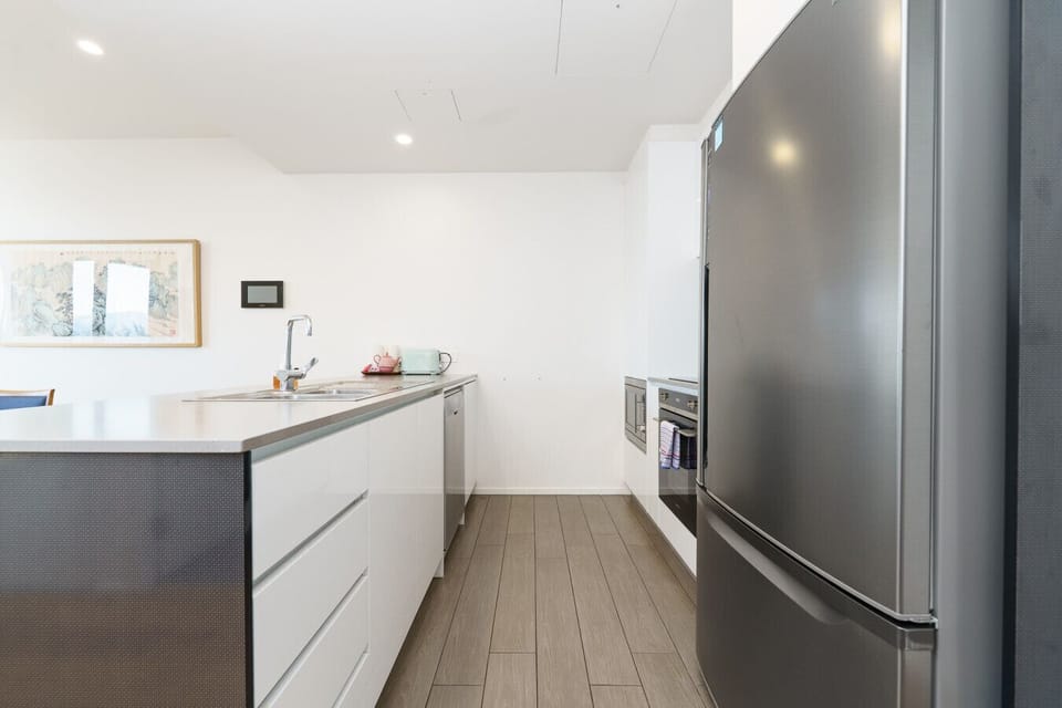 A clean, contemporary kitchen, complete with island seating, oven, and plenty of space