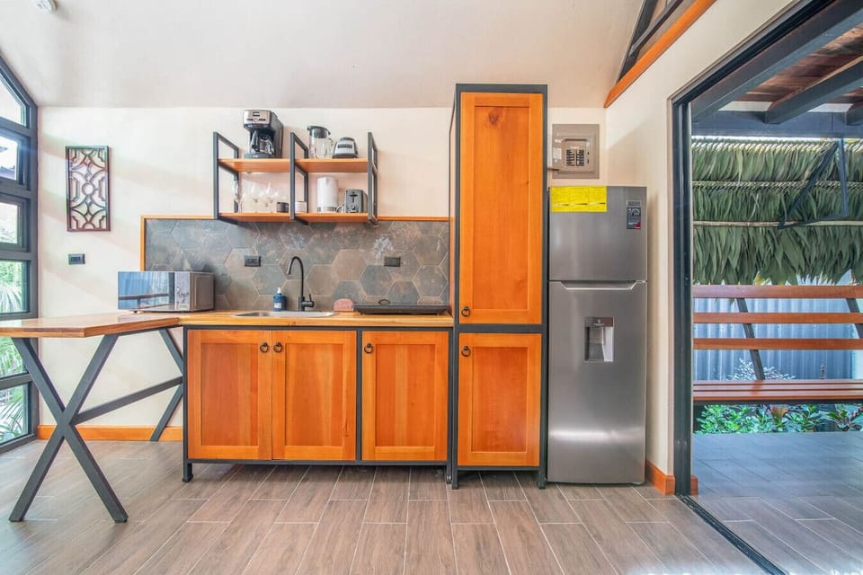 Fully equipped kitchen with wooden cabinetry, modern appliances, and natural light, Aloki Kalok 3 in Playa Chiquita