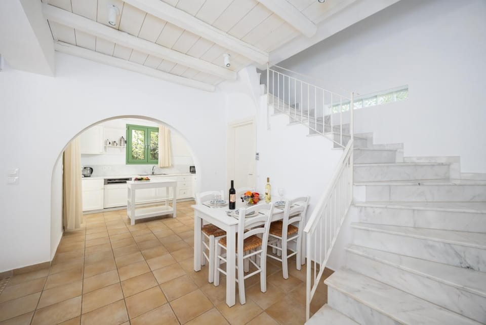 Open-plan living room with sofa, dining area, kitchen, A/C, WiFi internet, and satellite TV