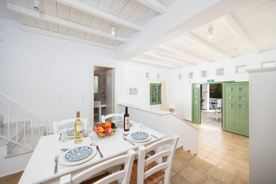 Open-plan living room with sofa, dining area, kitchen, A/C, WiFi internet, and satellite TV