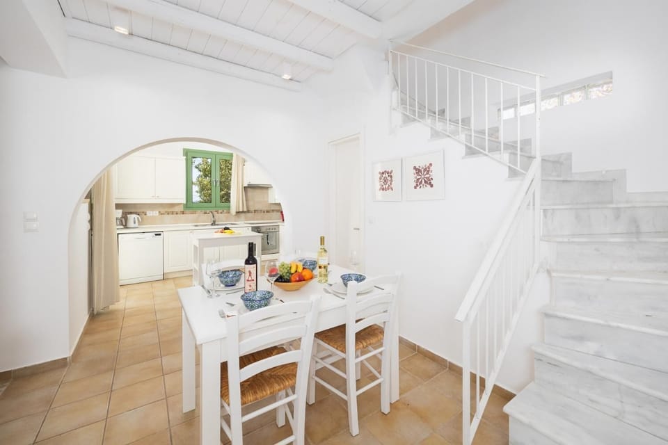 Open-plan living room with sofa, dining area, kitchen, A/C, WiFi internet, and satellite TV