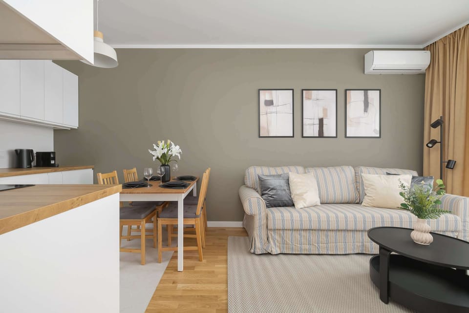 Air confitioned sitting area with double sofa bed, television, desk and coffee table.