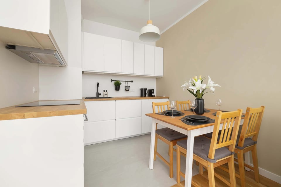 White and functional kitchenette with an oven, a fridge, a freezer and a kettle.