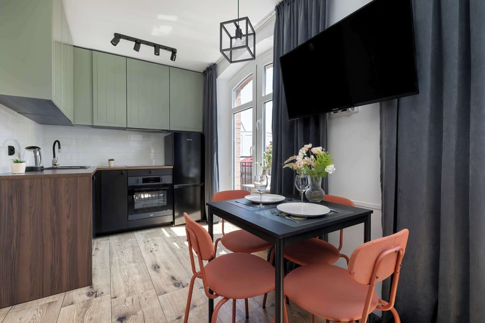 A contemporary kitchen space featuring two-tone cabinetry and a cozy dining area. Natural light enhances the warm color palette.