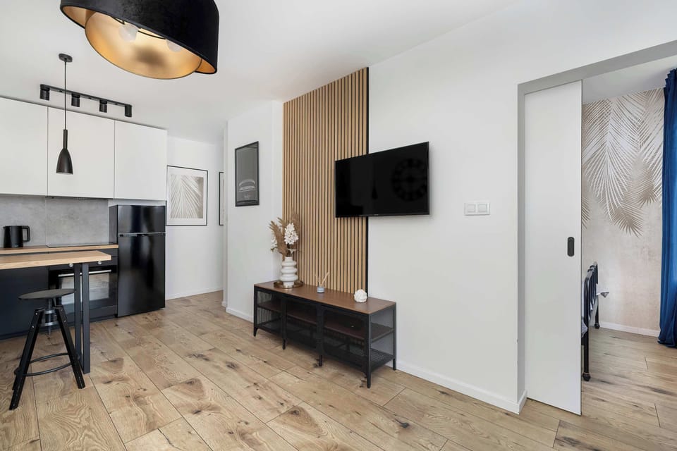 A cozy living area with a wall-mounted TV and sleek furniture, ideal for movie nights or everyday comfort.
