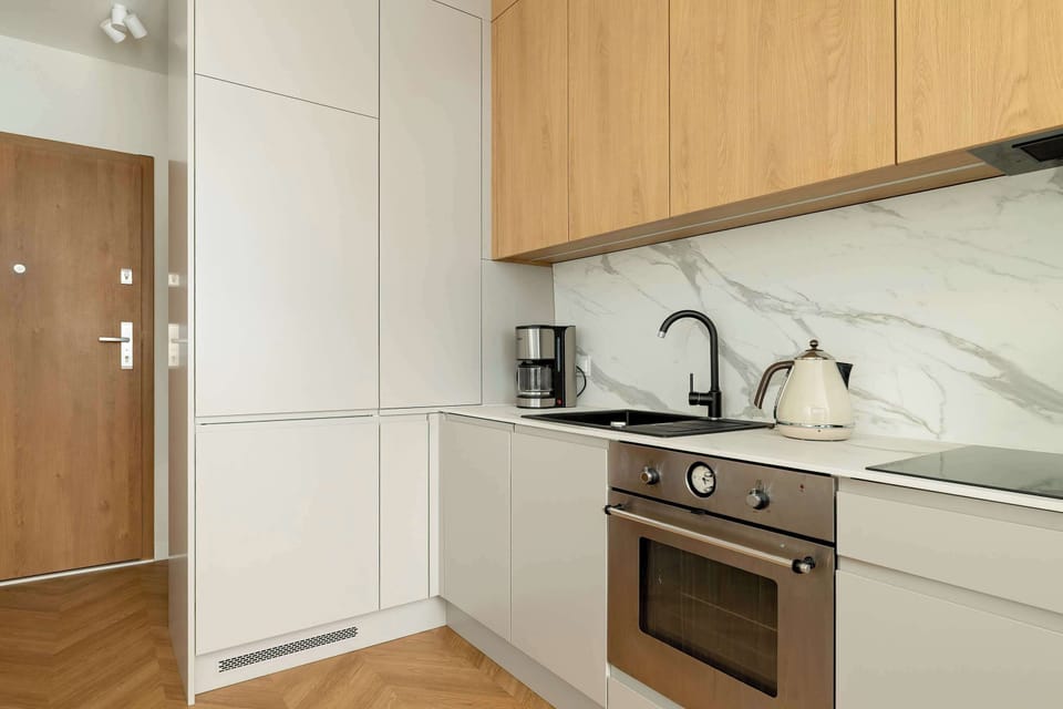 A compact kitchenette with built-in cabinets and a small dining area perfect for two.