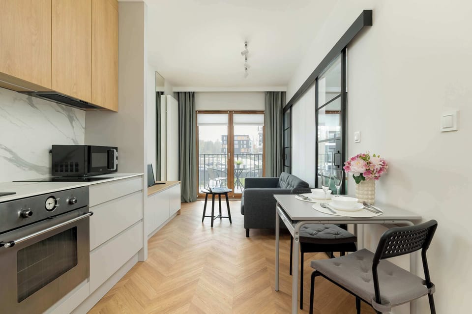 A compact kitchenette with built-in cabinets and a small dining area perfect for two.