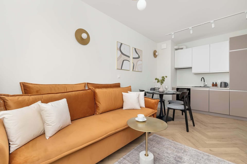 A focus on the copper-colored sofa in the living room. This piece adds warmth to the neutral decor.