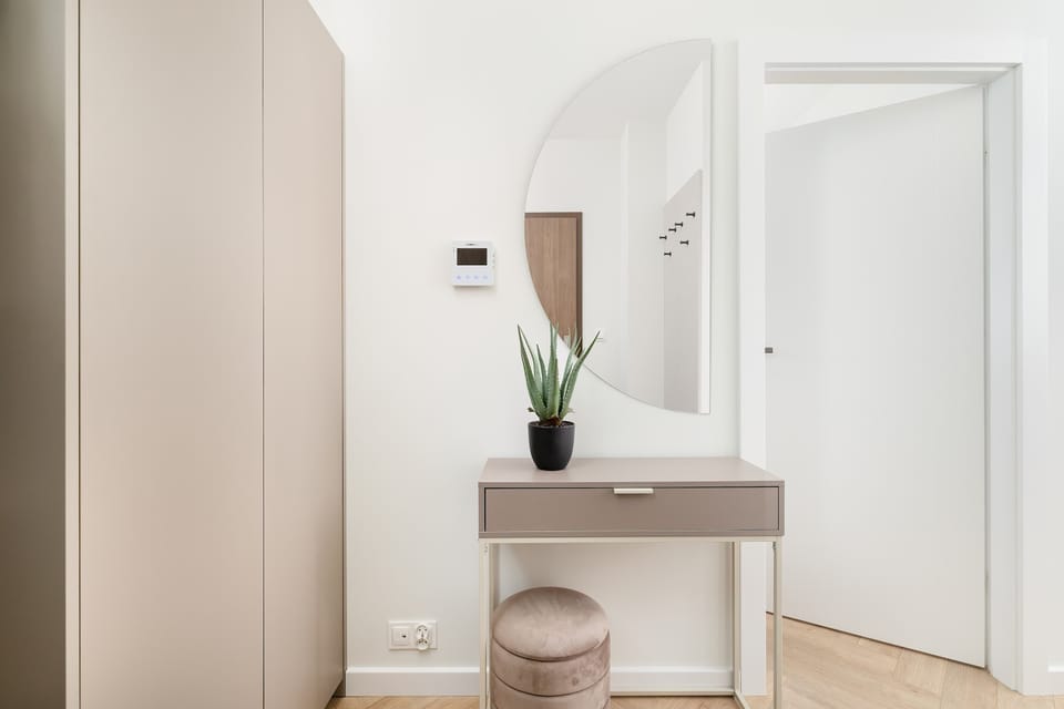 The hallway features a tall closet providing ample storage for coats and shoes. Its sleek design keeps the space tidy and organized.