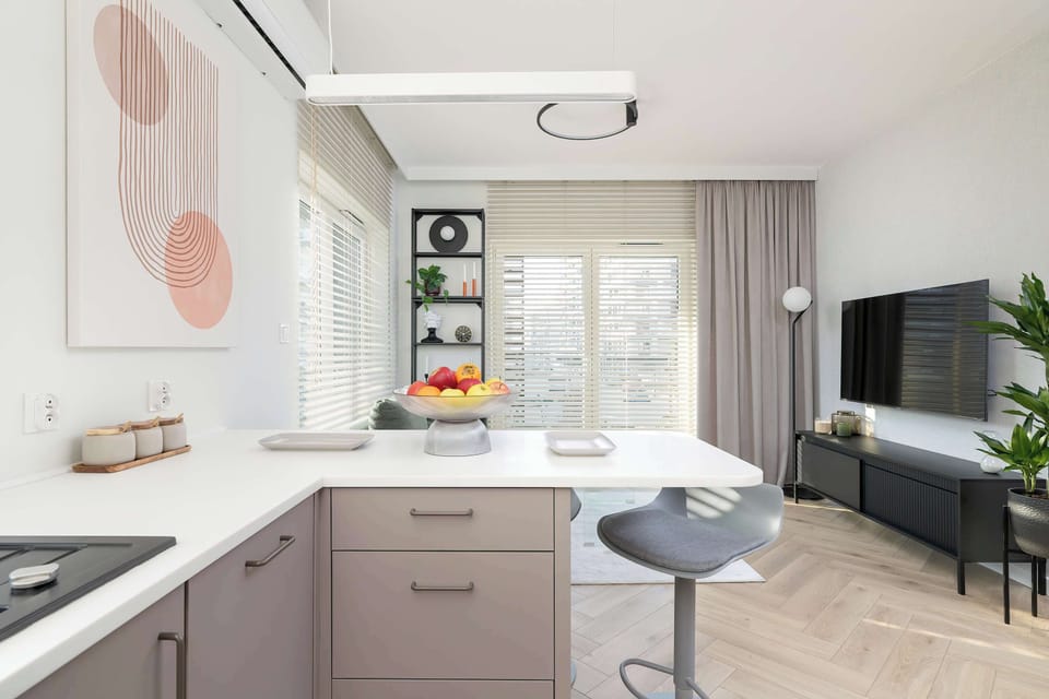 Modern kitchennette with all essentials, including an oven, transfer coffee maker, and induction cooktop, seamlessly connected to a charming dining space.