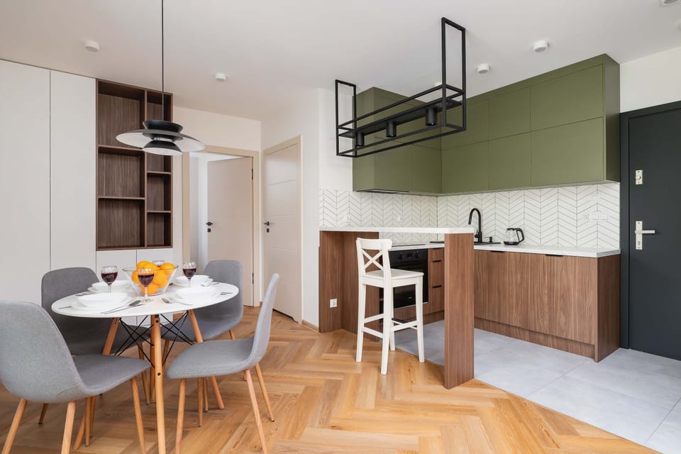 A compact and functional kitchen with modern fittings, a white backsplash, and wooden cabinetry. Ideal for cooking while staying connected to the living space.