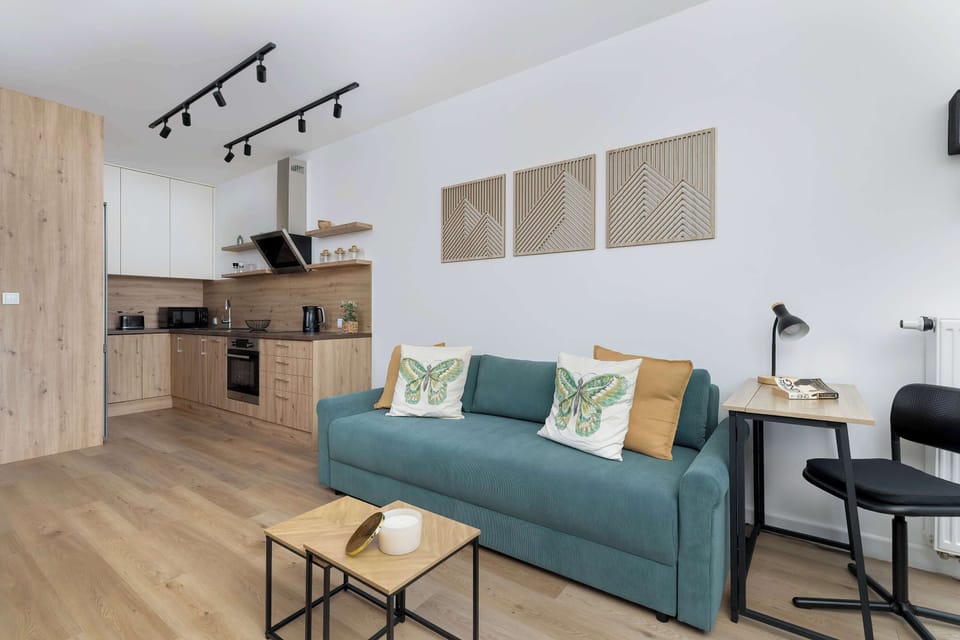 A modern living room with elegant furniture, muted decorations, and a large TV on the wall combines style with comfort.