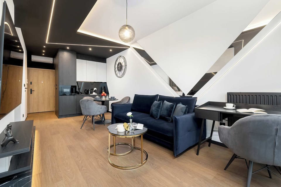 A stylish open-concept living space where the living room blends seamlessly with a modern kitchenette in the background.