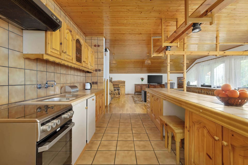 A charming country kitchen with terracotta tile floors, wood cabinetry, and natural light, ideal for family meals or vacation rentals.