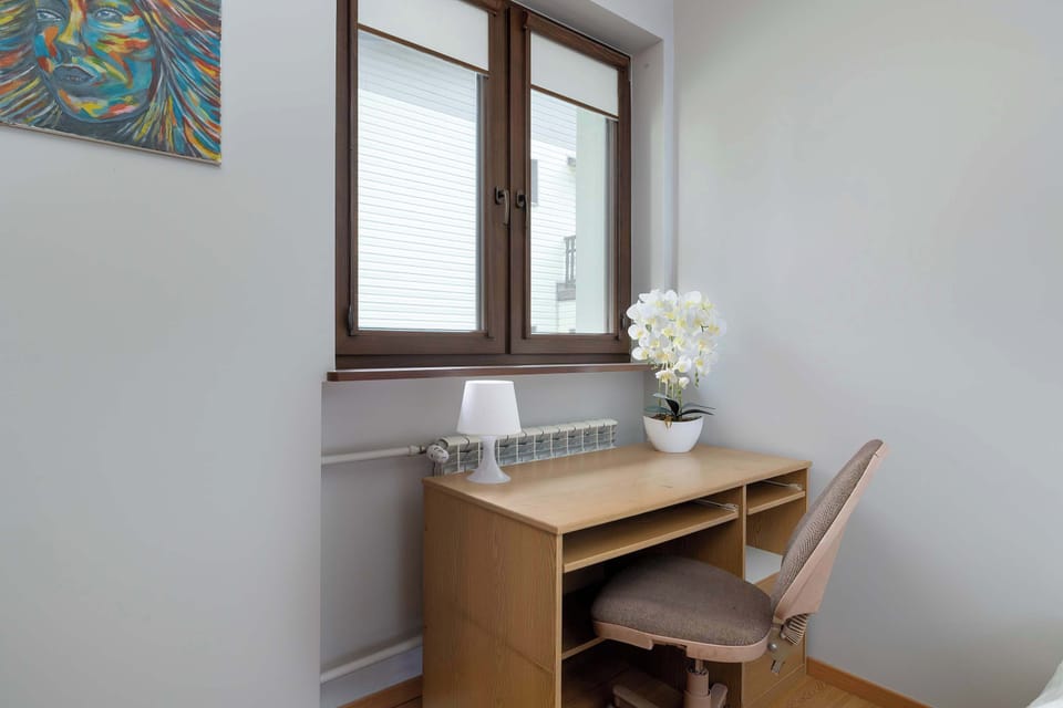 Small wooden desk and chair setup by the window – excellent for remote work or quiet moments.