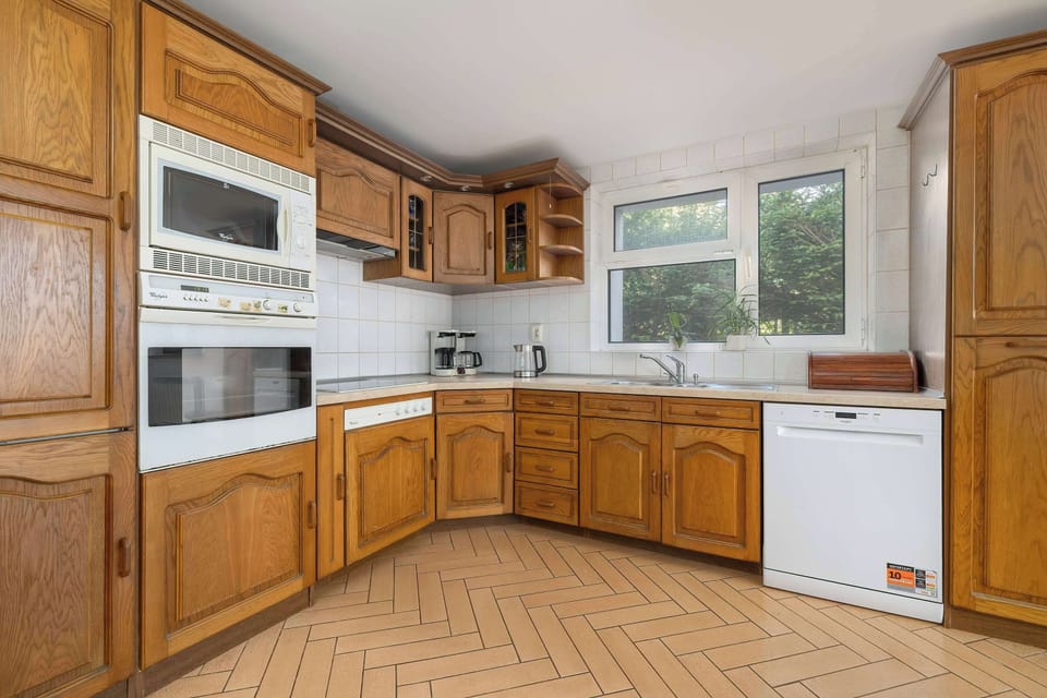 Practical, well-lit kitchen equipped with wooden cabinetry, full-sized appliances, and plenty of counter space – ideal for self-catering lodgings.
