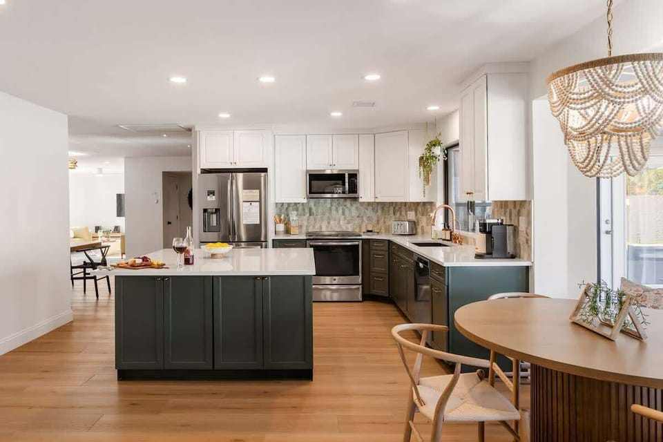 Fully equipped kitchen with stainless steel appliances, a kitchen island, and an informal dining area with seating for 5.