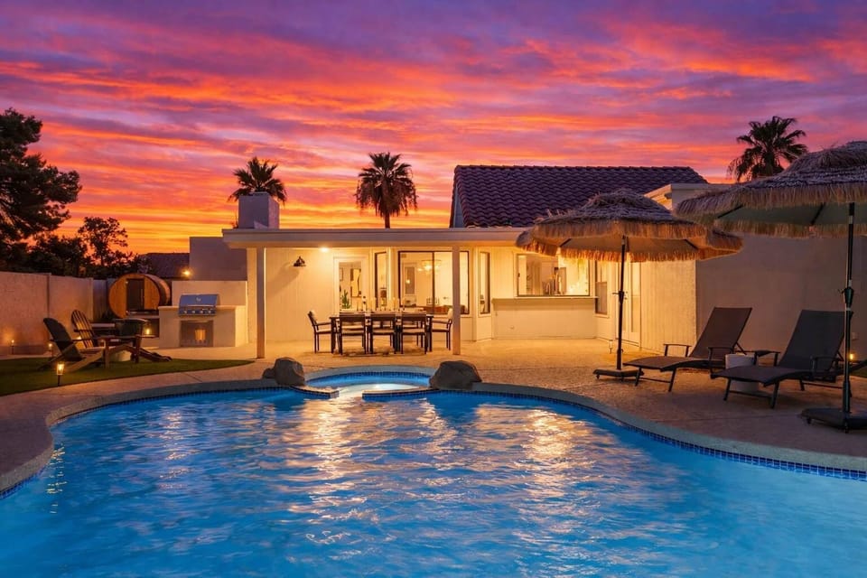 Resort-style backyard with a sparkling pool, sun loungers, outdoor dining area, grill, a cozy fire pit with surrounding seating, sauna, cold plunge, and outdoor shower.
