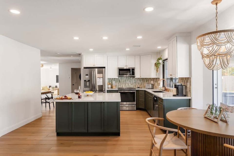Fully equipped kitchen with stainless steel appliances, a kitchen island, and an informal dining area with seating for 5.
