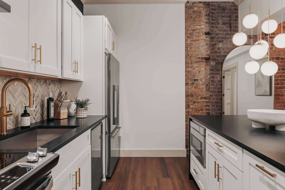 While fully equipped with modern conveniences, the kitchen retains the building’s historic charm with its original exposed brick walls.