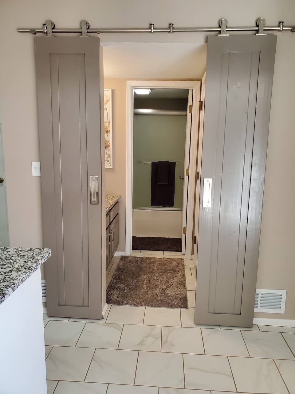 Stylish Barn doors lead to the bathroom and provide privacy to the split bathroom. 