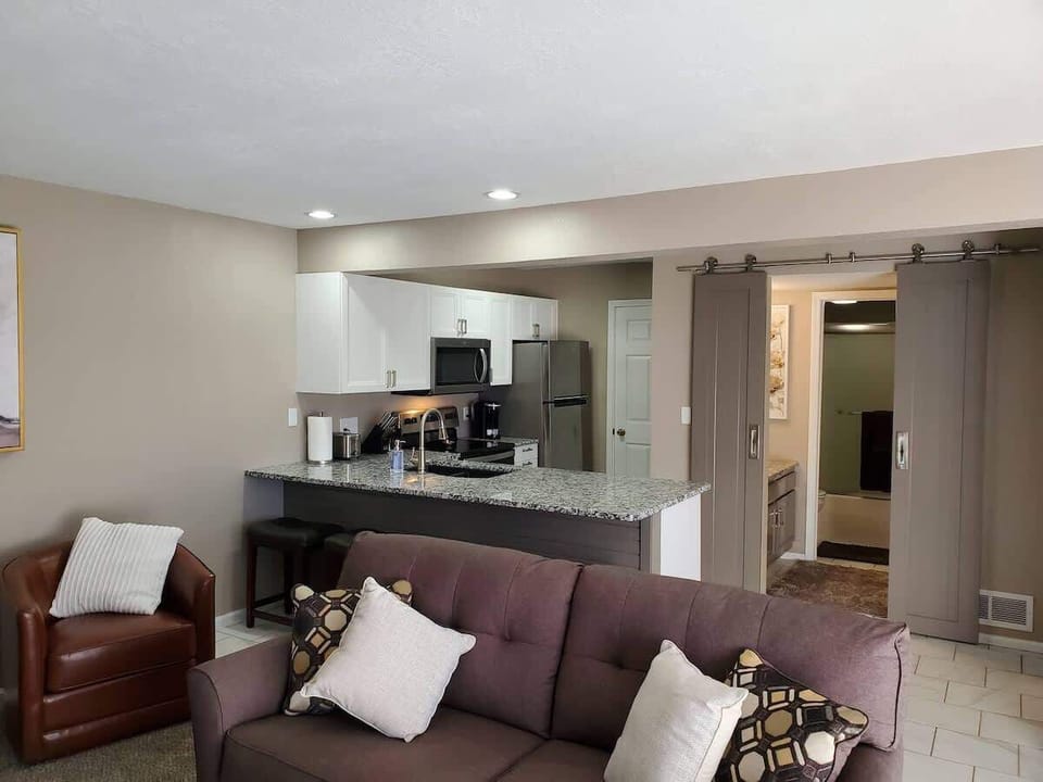 Living room with a pull-out couch equipped with a full-sized bed as well as two leather chairs