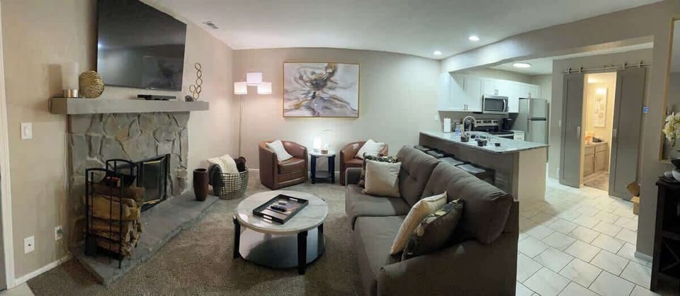 Comfortable and open floor plan, spacious living room with two chairs, pull-out couch, and wood-burning fireplace