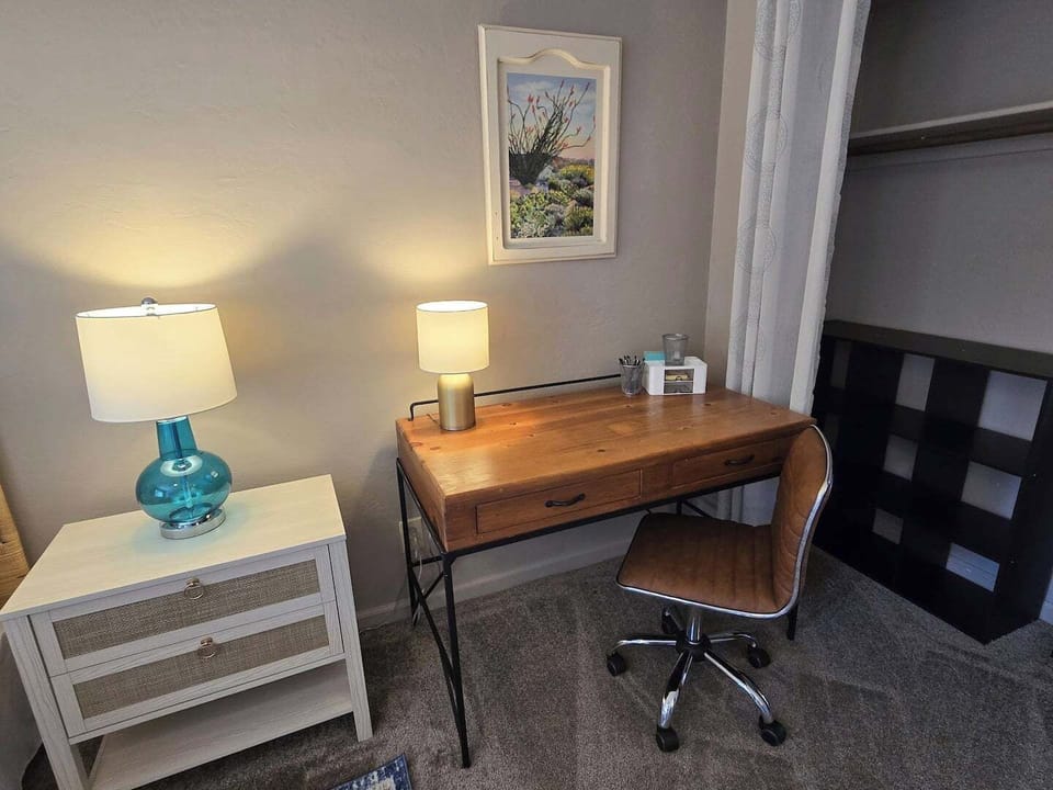 The primary bedroom is equipped with a desk and work lamp, offering a comfortable space if you need to work from home during your stay.
