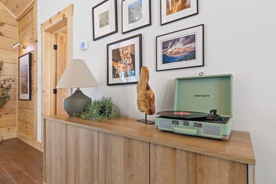 Spin your favorite vinyl with our bluetooth compatible record player! Underneath, you'll find a curated collection of records as well as a small book nook for a cozy read!