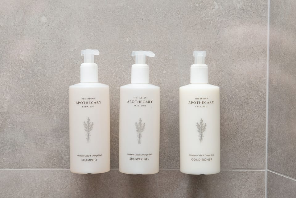 Designer toiletries, hair dryer, slippers, towels