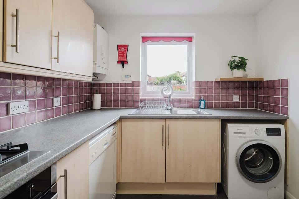 A functional kitchenette with generous worktop space, storage and a washing machine for added convenience.