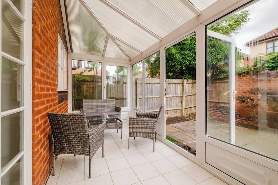 Step outside to a charming covered patio, with outdoor seating and a peaceful garden outlook.